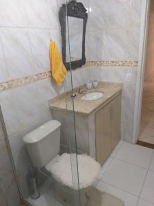 La salle de bains est pourvue de toilettes et d'un lavabo. dans l'établissement CASA DE FÉRIAS PRAIANA, à Cabo Frio