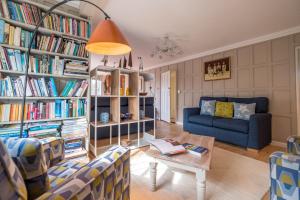uma sala de estar com um sofá, uma mesa e livros em 1 Westgate em Thorpeness