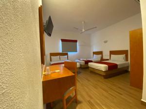 een hotelkamer met 2 bedden en een tafel bij Hotel LB in Manzanillo