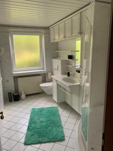 a bathroom with a sink and a toilet and a window at Ferienwohnung Obernkirchen in Obernkirchen