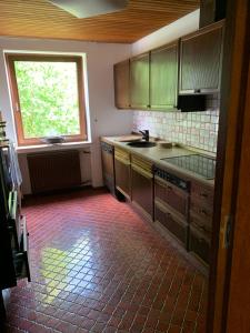 a kitchen with wooden cabinets and a large window at Ferienwohnung Obernkirchen in Obernkirchen