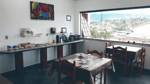 a restaurant with a table and chairs and a window at Pousada Vista da Pedra Atibaia in Atibaia