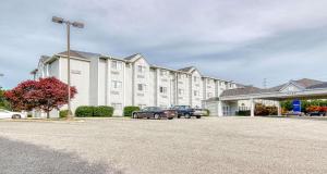 un gran edificio blanco con coches aparcados en un aparcamiento en SureStay Hotel by Best Western Christiansburg Blacksburg en Christiansburg