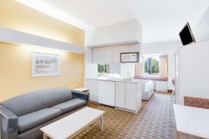 a living room with a couch and a kitchen at SureStay Hotel by Best Western Christiansburg Blacksburg in Christiansburg