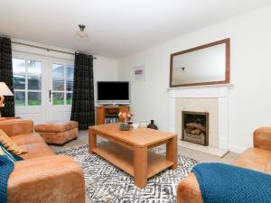 a living room with a table and a fireplace at Fistral Bay Cottage in Newquay