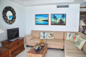 uma sala de estar com um sofá e uma televisão em Apartamentos con espectacular vista al mar em San Andrés