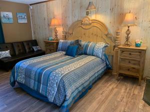 a bedroom with a large bed with a blue comforter at Grey Squirrel Resort in Big Bear Lake +162 photos