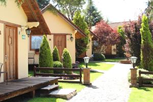 un jardín con un banco de madera y una casa en Cabañas Sierra Mazamitla, en Mazamitla
