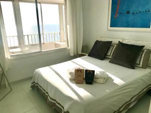 a large white bed in a room with a window at Mareny Blau, primera linea de playa in Mareny Blau