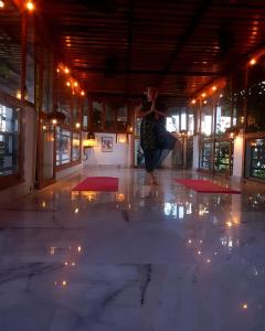 a woman dancing in a room with lights on the floor at Inn Seventh Heaven in Pushkar