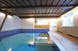 a swimming pool in a house with a wooden ceiling at Aparthotel Landhaus St. Joseph (Indoor Pool) in Mayrhofen