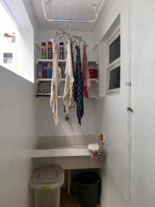 a bathroom with a toilet and a shelf with ties at Apartamento PRAIA do TOMBO - Guarujá in Guarujá