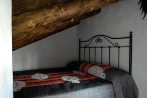 a bed in a bedroom with a wooden ceiling at Casa Juan in Orihuela del Tremedal