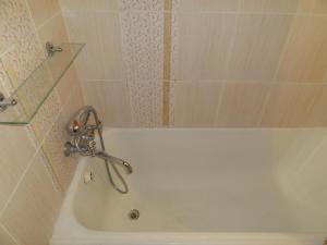 een wit bad met een kraan in de badkamer bij Kislovodsk Guests House in Kislovodsk