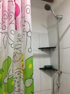 una tenda da doccia in un bagno accanto a un soffione a rose; di Asiriq Wasi Guest House a Cuzco