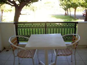 a white table and two chairs on a balcony at Yiota Studios in Alykes