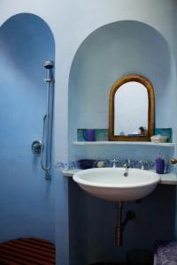 Baño azul con lavabo y espejo en Le Tre Colombe, en Bagno a Ripoli