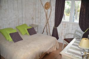a bedroom with a bed with green pillows and a table at Les Gîtes Les Mayombes in Roquebrune-sur-Argens +86 photos