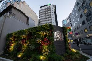 un gran arbusto con flores al lado de un edificio en R&B Hotel Nagoya Ekimae en Nagoya