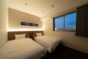 twee bedden in een kamer met een raam bij Washington R&B Hotel Nagoya Ekimae in Nagoya