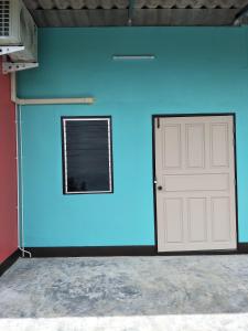 un mur bleu avec une porte de garage et une fenêtre dans l'établissement Home hug villa, à Ban Bang Rin (1)