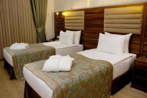 a hotel room with two beds with towels on them at Adanava Hotel in Adana
