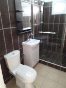La salle de bains est pourvue d'une douche et de toilettes blanches. dans l'établissement Holiday home, à Larnaka
