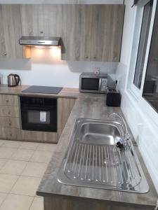 a kitchen with a sink and a microwave at Holiday home in Larnaca