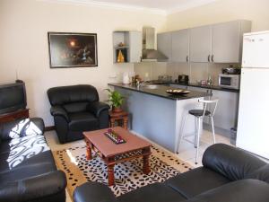 a living room with a couch and a kitchen at Littlefield Luxury Suite in Johannesburg