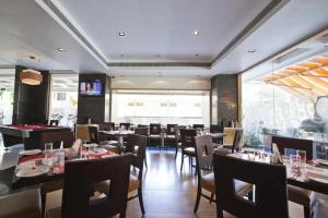 浦那Spree Shivai Hotel Pune的餐厅里有桌椅的餐厅