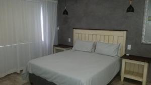 een slaapkamer met een wit bed en 2 nachtkastjes bij Guest house on Gillian Unit 1 in Ballito