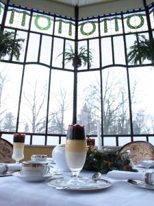 una mesa con mantel blanco y un vaso de leche en Rezydencja Janków en Iłowa