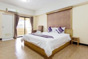 a bedroom with a large bed with purple pillows at P-Park Hotel near Yanhee Hospital - SHA Extra Plus in Bangkok