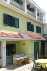 a building with a bench and a table in front of it at Alborada B&B in Salerno