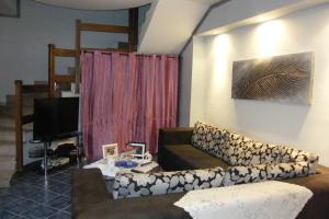 ein Wohnzimmer mit einem Sofa und einem TV in der Unterkunft Alborada B&B in Salerno