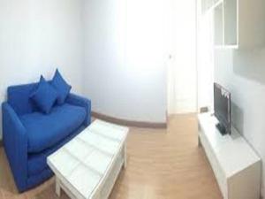 uma sala de estar com um sofá azul e uma televisão em Room in Apartment - Near Impact Challenger Bangkok Thailand can walk em Nonthaburi