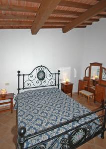 a bedroom with a bed with a blue comforter at Villa Poderino by PosarelliVillas in Bibbona