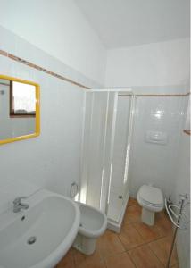 bagno bianco con lavandino e servizi igienici di Villa Poderino by PosarelliVillas a Bibbona