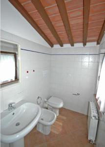 bagno bianco con lavandino e servizi igienici di Villa Poderino by PosarelliVillas a Bibbona