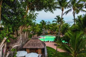 a view of a resort with a pool and palm trees at Canonnier Beachcomber Golf Resort & Spa in Pointe aux Canonniers