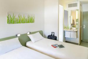 ein Schlafzimmer mit einem Bett mit einem Tablet darauf in der Unterkunft Ibis budget Hamburg Quickborn in Quickborn