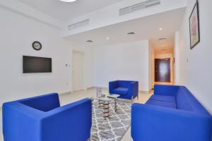 een woonkamer met twee blauwe stoelen en een tafel bij OYO 597 Home al khail heights 335, G19 in Dubai