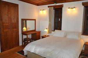 een slaapkamer met een groot wit bed en een spiegel bij Ionia House in Selcuk