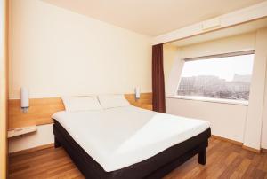 a bedroom with a bed and a window at Ibis Graz in Graz