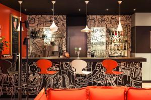 a bar with orange chairs and a wall covered in graffiti at Ibis Graz in Graz