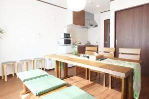 eine Küche und ein Esszimmer mit einem Holztisch und Stühlen in der Unterkunft Fukenouchi House in Kyoto