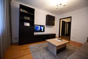 - un salon avec un canapé et une télévision dans l'établissement Nordic, à Suceava