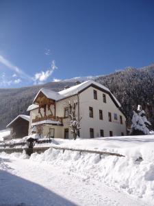 un edificio con nieve en el suelo delante de él en Haus Obernig, en Mallnitz