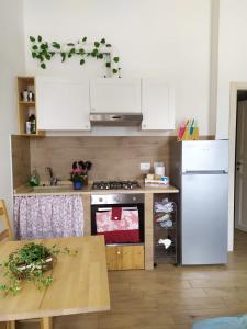 a kitchen with a stove and a refrigerator and a table at AGRITURISMO " LE SERRE" in Spello