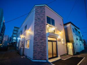 a brick building with lights on the side of it at Tomoeドットコム2 onepiecehouse in Hakodate